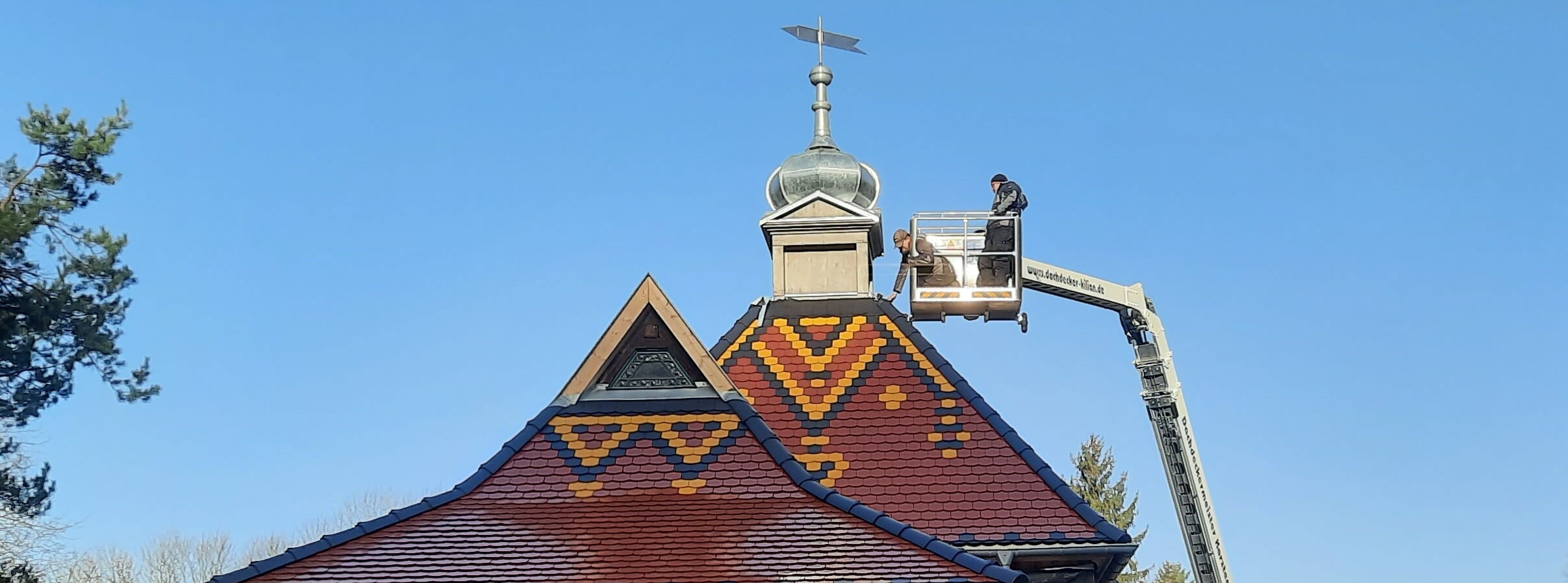 Die Turmhaube mit Wetterfahne wird auf den Fürstenpavillon aufgesetzt